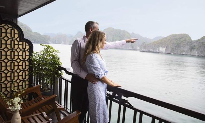 guests stand at the balcony on Halong Bay Cruise